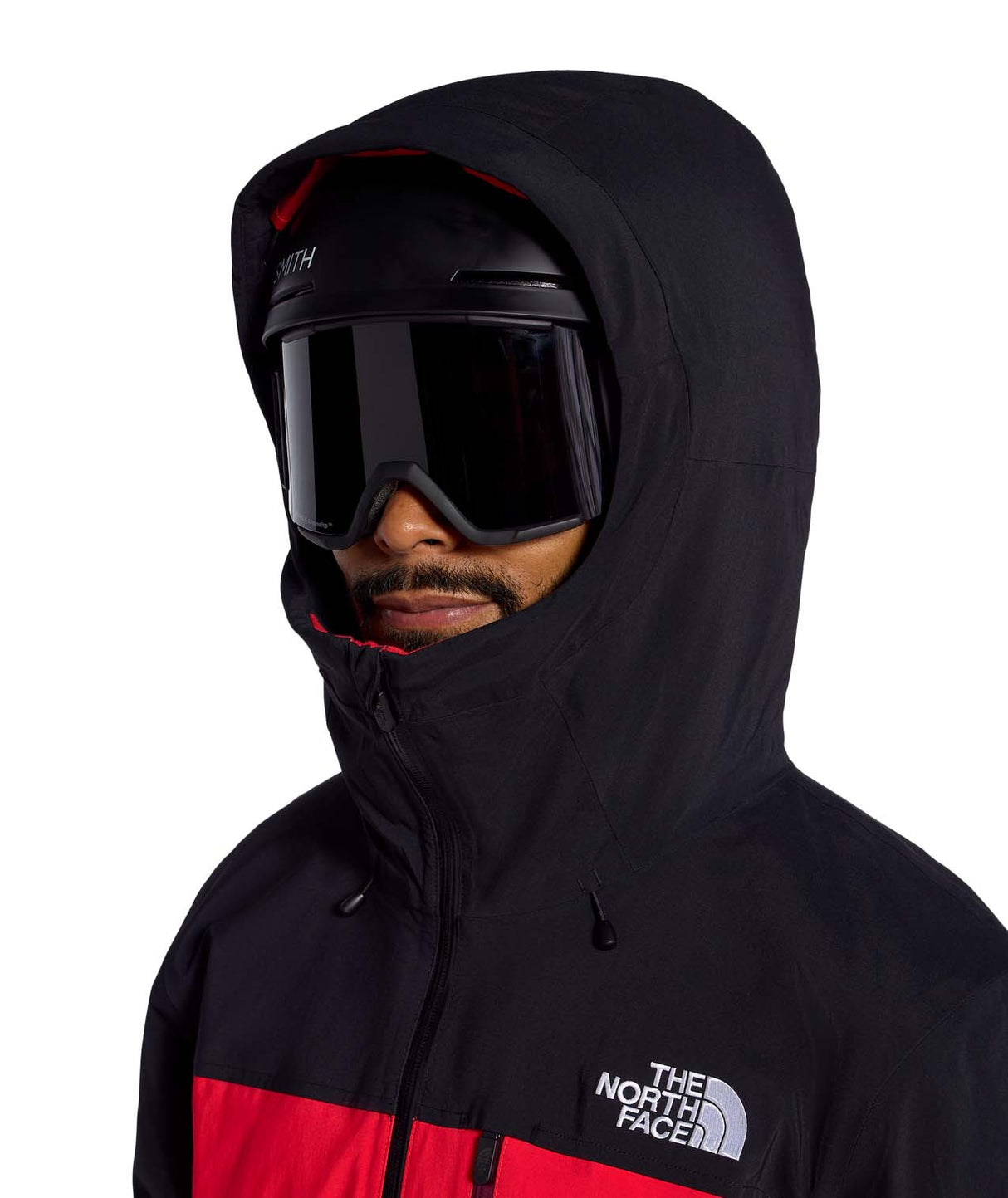 MFreedomInsulatedJacket- Person wearing a black and red The North Face jacket with a helmet and goggles on a white background