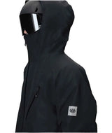MHydraThermagraphJacket-A man wearing a black ski jacket with black zippers, black gloves, a cream neck gaiter, and a black beanie with goggles, photographed against a plain white background.