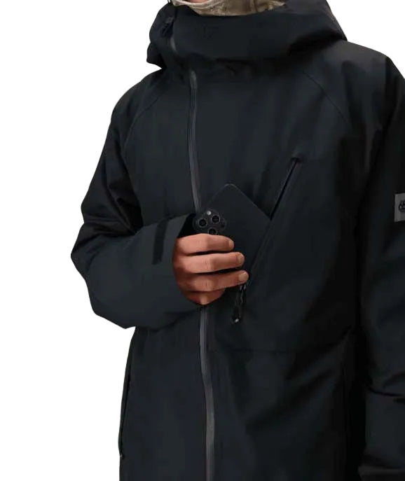 MHydraThermagraphJacket-A man wearing a black ski jacket with black zippers, black gloves, a cream neck gaiter, and a black beanie with goggles, photographed against a plain white background.