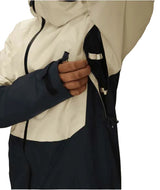 MHydraThermagraphJacket-A man wearing a color-blocked ski jacket in beige and black, along with black snow pants, gloves, and ski goggles, photographed against a solid white background.