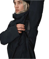 MHydraThermagraphJacket-A man wearing a black ski jacket with black zippers, black gloves, a cream neck gaiter, and a black beanie with goggles, photographed against a plain white background.
