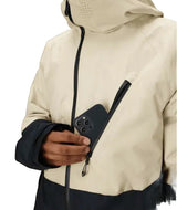 MHydraThermagraphJacket-A man wearing a color-blocked ski jacket in beige and black, along with black snow pants, gloves, and ski goggles, photographed against a solid white background.