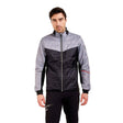 MMayenQuiltedJacket- A man wearing a gray and black color-blocked puffer jacket with black pants, standing against a solid white background.