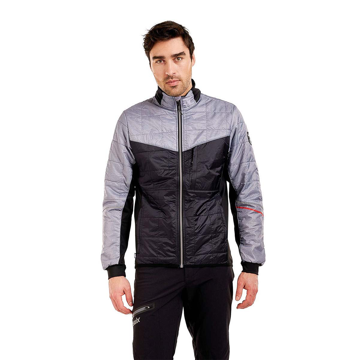 MMayenQuiltedJacket- A man wearing a gray and black color-blocked puffer jacket with black pants, standing against a solid white background.