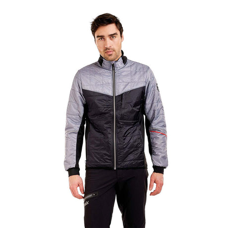 MMayenQuiltedJacket- A man wearing a gray and black color-blocked puffer jacket with black pants, standing against a solid white background.