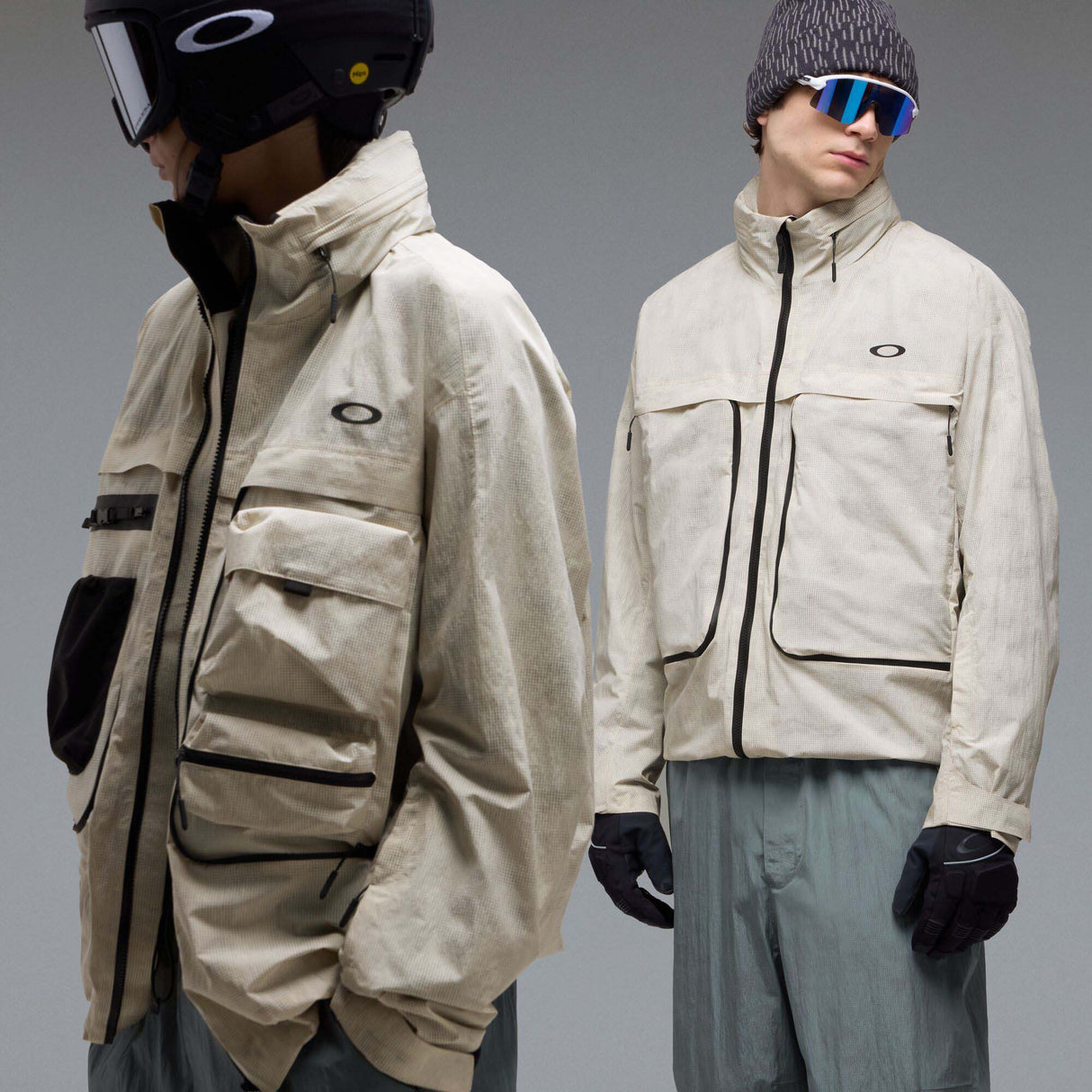 MMthodGlowShellJacket-A light beige technical jacket with black zippers, black piping details, and an Oakley logo on the left chest, displayed against a neutral gray background.