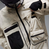 MMthodGlowShellJacket-A light beige technical jacket with black zippers, black piping details, and an Oakley logo on the left chest, displayed against a neutral gray background.