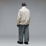 MMthodGlowShellJacket-A light beige technical jacket with black zippers, black piping details, and an Oakley logo on the left chest, displayed against a neutral gray background.
