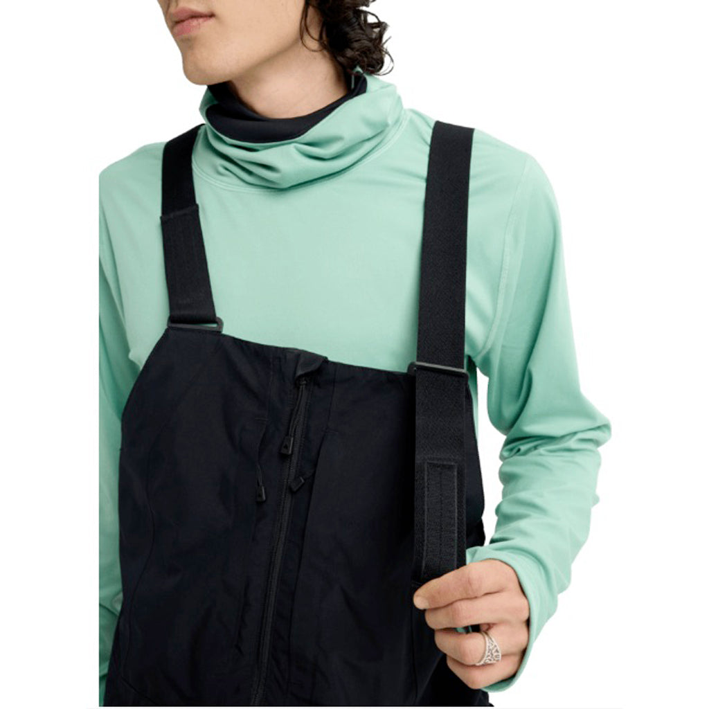 MReserveGORE-TEX2LBib-Person wearing a light green long-sleeve shirt and black overalls on a white background
