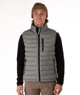 MSawyerPuffyVest-Man wearing a grey puffer vest over a black shirt on a white background