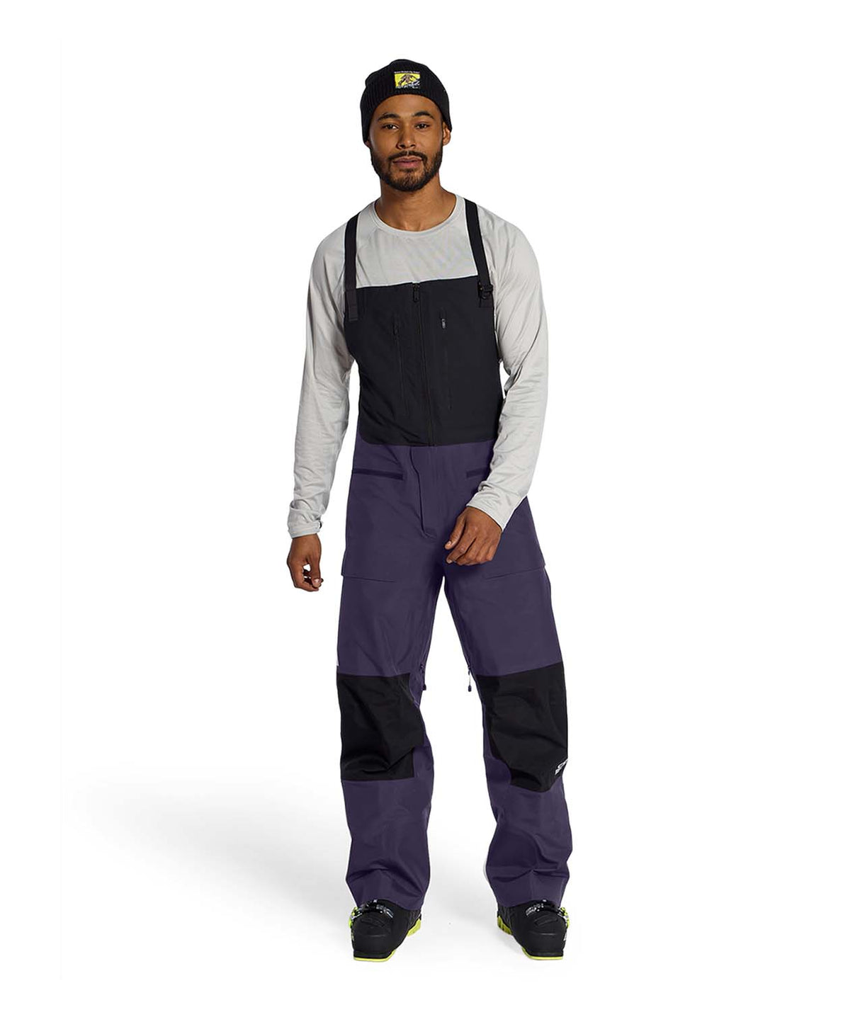 MSummitVerbierGTXBib-Man wearing a black and purple bib overalls on a white background