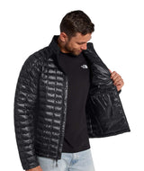MTHERMOBALLJacket-Man wearing a black quilted jacket with a brand logo on a white background