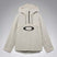 MTimberlineShellAnorak-An off-white hooded anorak jacket with a large black Oakley logo on the chest, displayed against a neutral gray gradient background.