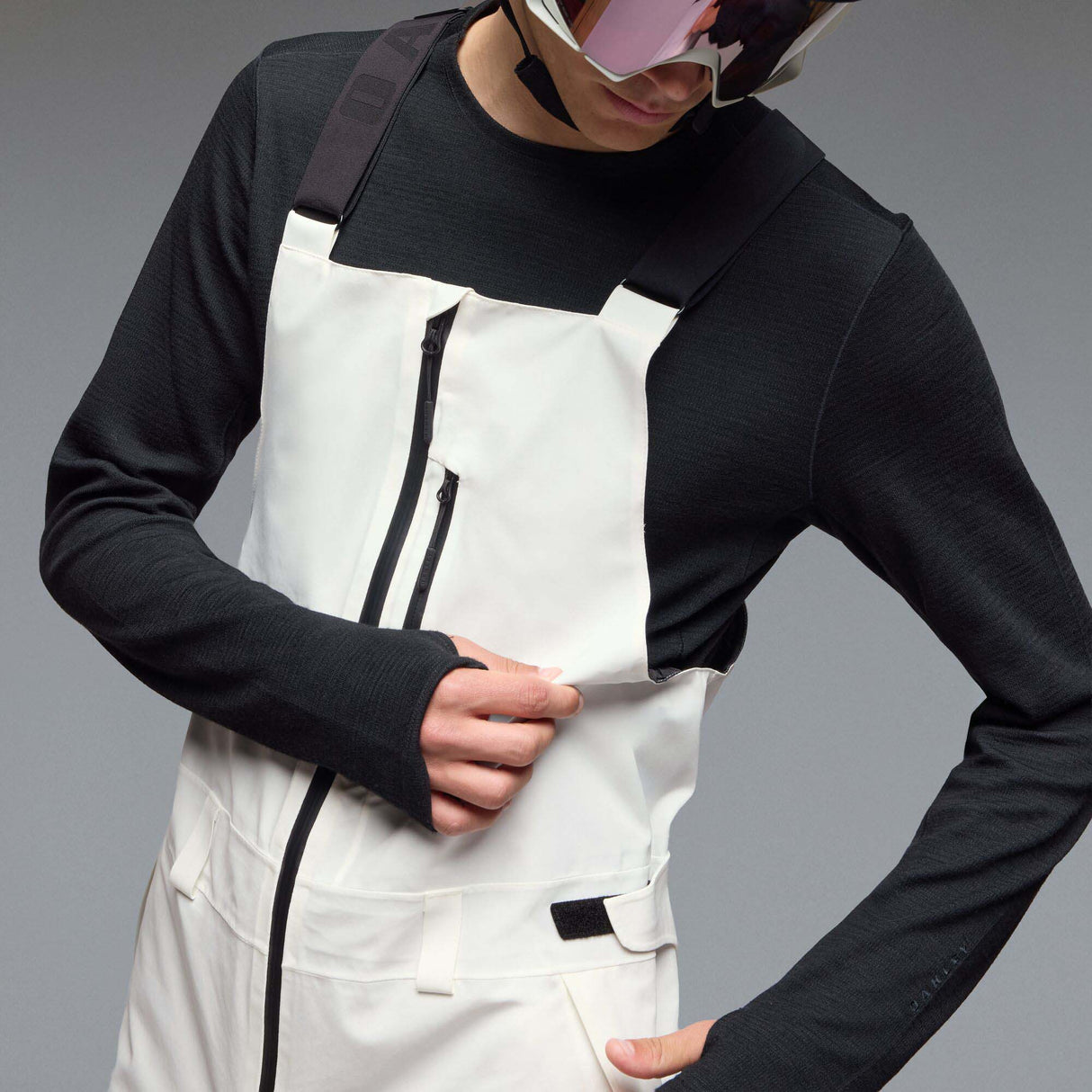MTimberlineShellBib-A white and black technical snow bib with adjustable shoulder straps, a front zipper, and reinforced lower leg panels, shown against a neutral gray gradient background.