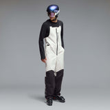 MTimberlineShellBib-A white and black technical snow bib with adjustable shoulder straps, a front zipper, and reinforced lower leg panels, shown against a neutral gray gradient background.