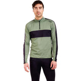 MTista1_2ZipMidlayer- A man wearing a sage green and black long-sleeve quarter-zip athletic pullover, paired with black pants, against a plain white background.