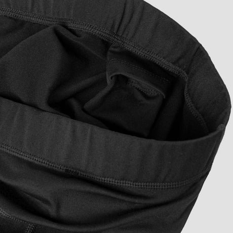 MTistaMidlayerTight- Black athletic leggings with an elastic waistband and a small gray logo on the lower left leg, shown against a plain white background.
