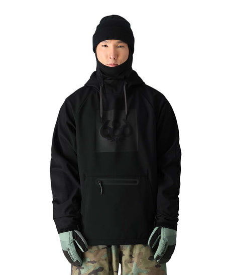 MWaterproofHoody-A model wearing a black hooded jacket with a high neck, black beanie, black gloves, and camouflage pants, shown against a plain white background.