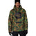 MWaterproofHoody-A man wearing a camouflage hooded jacket with a black chest patch featuring a skull graphic, paired with black pants, gloves, and a black beanie, against a plain white background.
