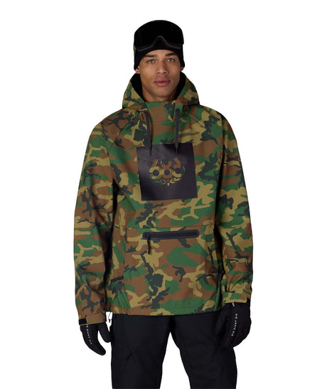 MWaterproofHoody-A man wearing a camouflage hooded jacket with a black chest patch featuring a skull graphic, paired with black pants, gloves, and a black beanie, against a plain white background.