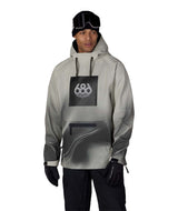 MWaterproofHoody-A man modeling a light gray and black 686 hooded snow jacket with a black chest logo, black pants, black gloves, and a black beanie with goggles, set against a plain white background.
