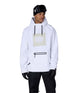 MWaterproofHoody-A man wearing a white hooded snowboard jacket with a beige square chest graphic, black drawstrings, and a black zipper pocket, paired with black pants, gloves, and a black beanie with goggles, against a plain white background.
