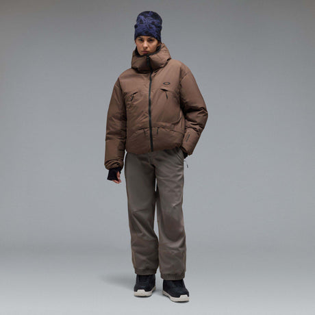 MWintertideSoftshellPant-A pair of gray snow pants with a black belt and a small black Oakley logo on the left thigh, displayed against a neutral gray gradient background.