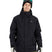 NateJacket-A man wearing a black XTM snowboard jacket, black beanie with green-tinted goggles, black gloves, and olive pants, standing against a solid white background.