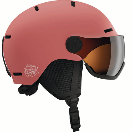 ORKAVISOR- A pink ski helmet with a black chin strap and a large black visor featuring an orange-tinted lens, shown against a plain white background.