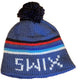 OleHat- A blue knit beanie hat with a black pom-pom on top, featuring horizontal stripes in red, black, light blue, and white, with white lettering reading 'SWIX' on the front.
