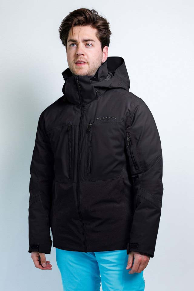 OrionMensInsulatedJacket-A man wearing a black hooded ski jacket with multiple zippered pockets and bright turquoise pants, standing against a light gray studio background.