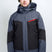 OrionMensInsulatedJacket-A man wearing a Karbon ski jacket in dark gray and black, with a green beanie, ski goggles, and gray pants, photographed against a light gray studio background.