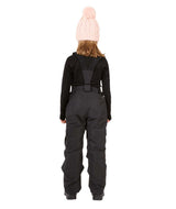 PlutoIIKidsPant-A child shown from the back wearing a light pink knit beanie with a pom-pom, a black long-sleeve top, and dark gray snow bib overalls with a black harness strap, set against a plain white background.