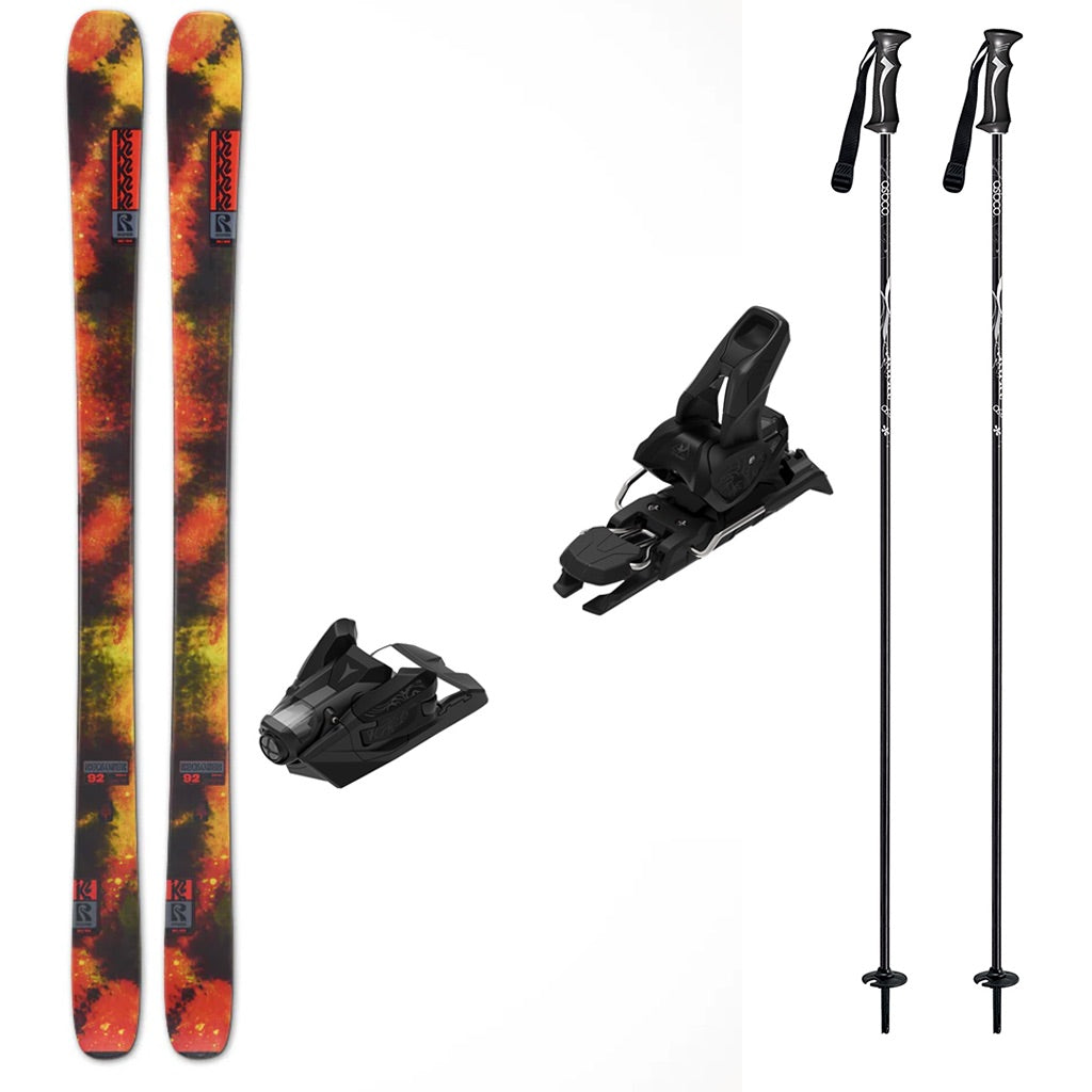 Reckoner92w_Strive12- A ski gear bundle featuring a pair of K2 skis with a vibrant orange, yellow, and black flame-patterned, two black Atomic bindings, and two black ski poles on a plain white background.