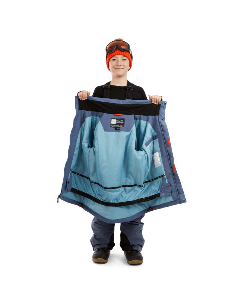 RumbleJacket- A child wearing a blue snowboard jacket, black gloves, and an orange beanie with ski goggles on a white background.