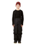 ScoobieIIPant-A child model wearing black snow bib overalls with suspenders, a black long-sleeve shirt, black snow boots, and a burgundy knit beanie, standing against a solid white background.