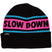 SlowDownBeanie- An black knit beanie with a pink horizontal stripe across the middle featuring the words 'SLOW DOWN' in black. The beanie also has light blue stripes above and below the white band and a small black 'SPIRAL' brand tag on the folded cuff.