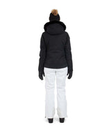 SolaceJacket-A woman wearing a black ski jacket with a faux-fur trimmed hood, black gloves, a black beanie, and ski goggles, posed against a solid white background.