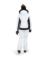 SolaceJacket-A woman wearing a white and black ski jacket with a black fur-trimmed hood, black gloves, a black beanie, and ski goggles, posed against a solid white background.