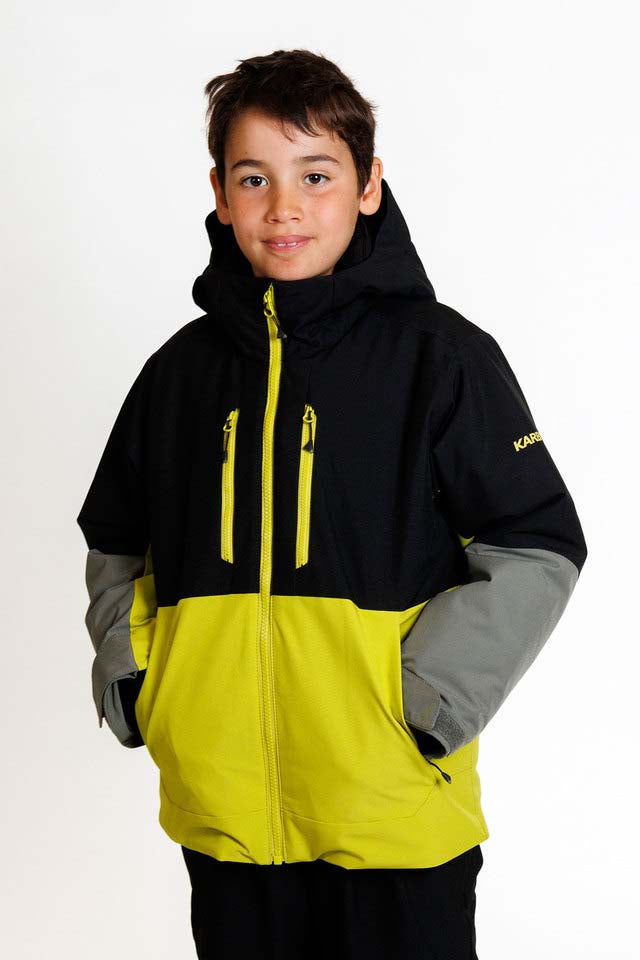 SquallKidsInsulatedJacket-A child wearing a hooded ski jacket with a black upper section, bright yellow lower section and zipper details, and gray sleeves, photographed against a plain white studio background.