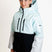 SquallKidsInsulatedJacket-A young girl wearing a light blue and black color-blocked hooded jacket with light gray sleeves, standing against a plain white studio background.