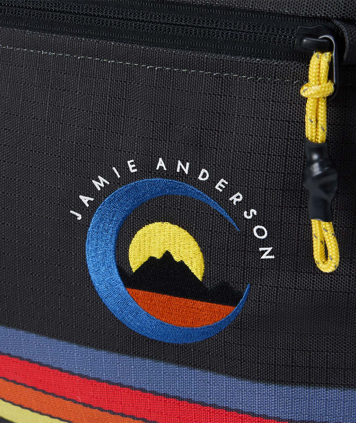 TeamLowRollerSnowboardBagJamieAnderson-Black snowboard bag with colorful stripes and Dakine branding on a white background