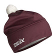 TistaBeanie- A maroon athletic beanie with a white pom-pom on top and a white 'swix' logo on the side, shown against a plain white background.