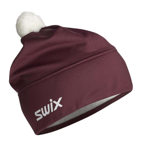 TistaBeanie- A maroon athletic beanie with a white pom-pom on top and a white 'swix' logo on the side, shown against a plain white background.