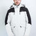 TritonMensInsulatedJacket-A man wearing a Karbon colorblock ski jacket in off-white and black, paired with gray pants, standing against a light gray studio background.