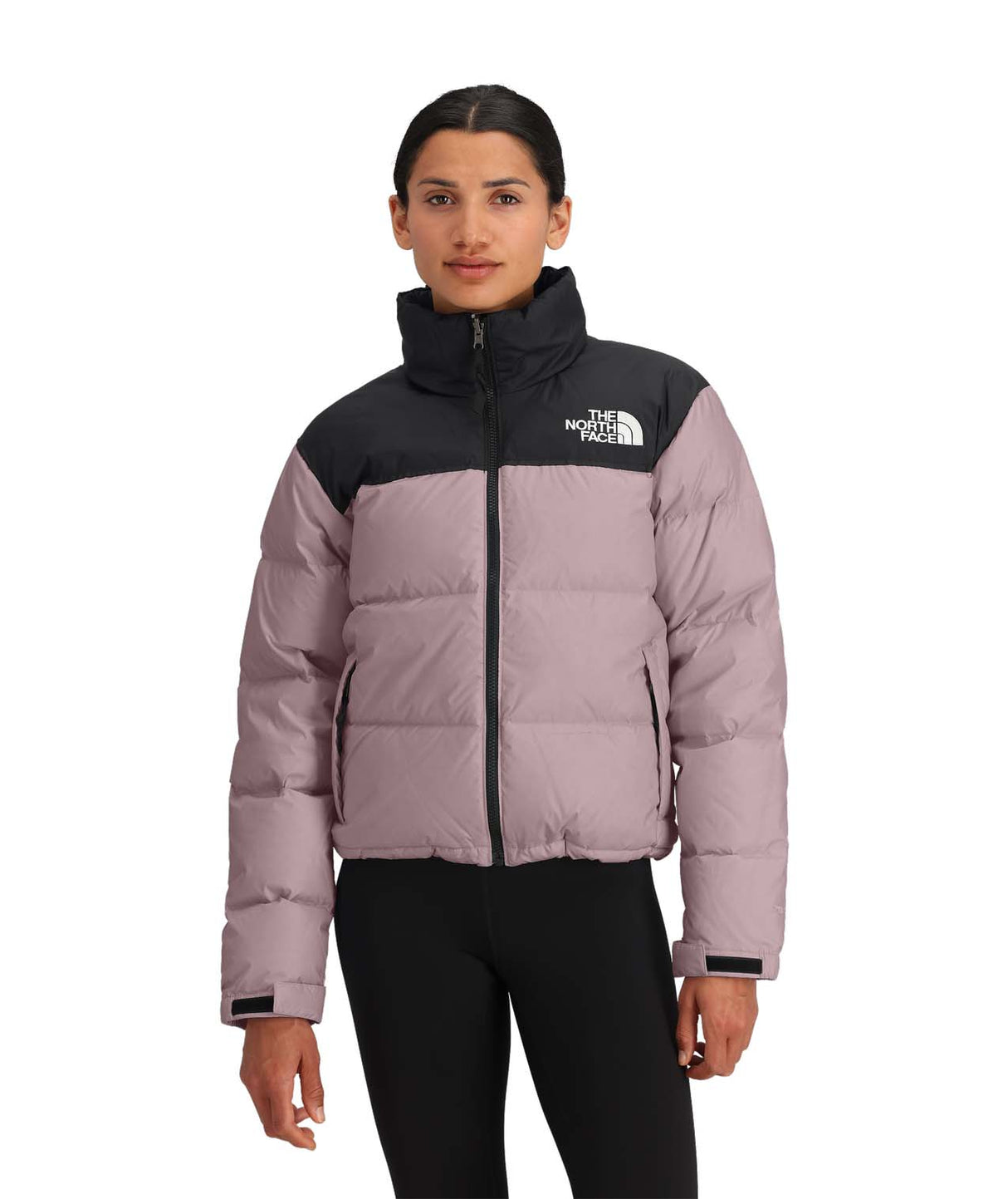 W1996RetroNuptseJacket-Person wearing a pink and black jacket with The North Face logo on a white background