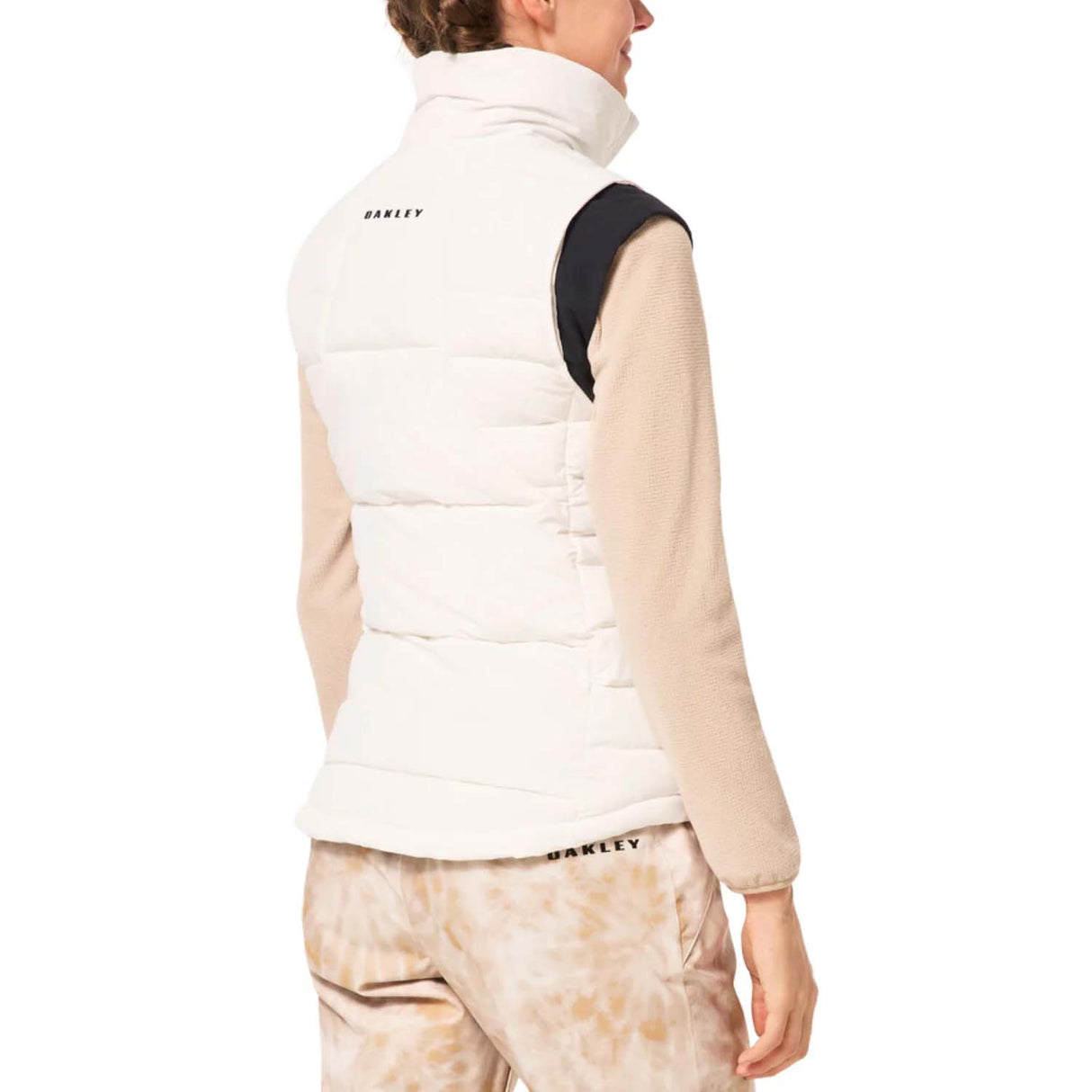 WAutumnRCVest-Person wearing a white puffer vest over a beige long-sleeve shirt on a white background