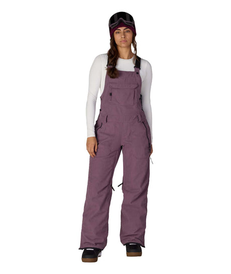 WBlackMagicInsulatedBib-Person wearing purple bib overalls on a white background