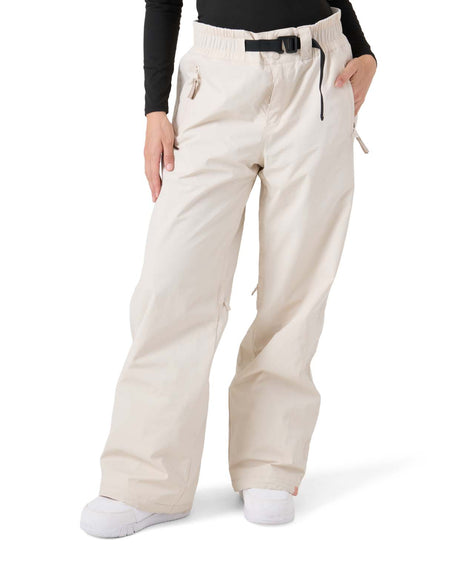 WBleekerPant- Woman wearing cream snow pants with black belt on a white background