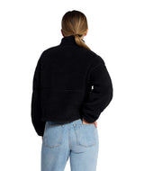 WExtremePile2Pullover- Person wearing a black fleece pullover with a brand logo on a white background